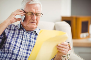 Senior man talking to phone scammer