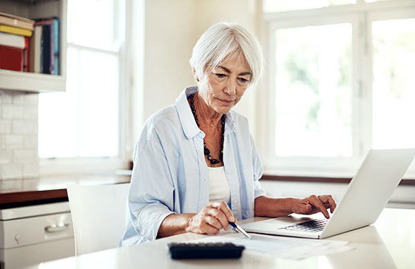 Senior woman at laptop in kitchen