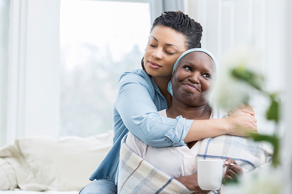 Mid adult woman embraces her senior mom