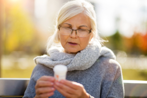 Senior woman checking label on medication