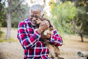 An African American senior man playing with his dog