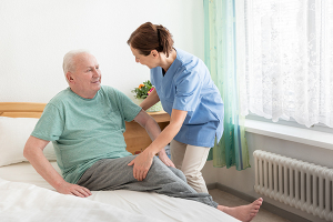 Nurse helping patient get up from bed. Elderly Care