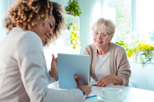 Smiling senior woman talking with advisor, sitting at the table