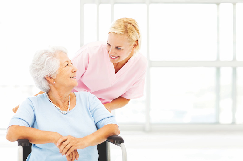 caregiver pushing senior client in a wheelchair