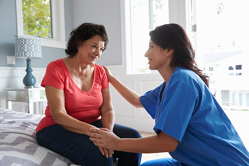 caregiver consoling senior woman