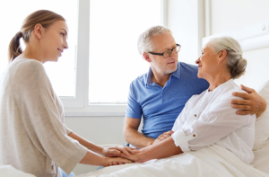 happy family visiting senior woman at hospital