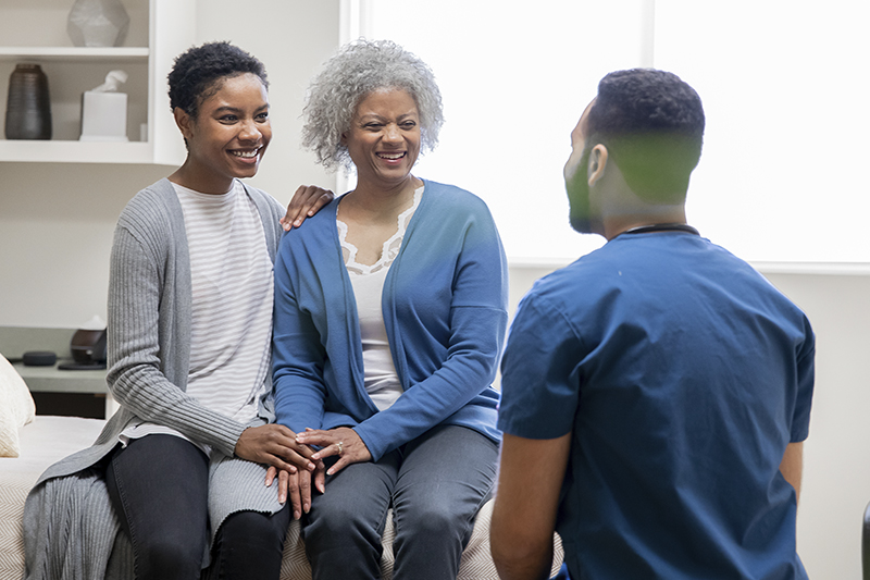 medical-professional-talking-to-adult-daughter-and-senior-mother