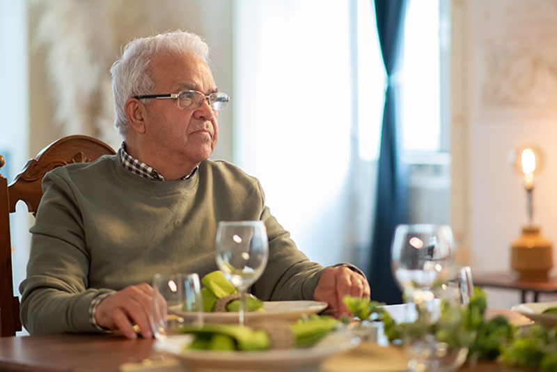 senior-man-sitting-at-dinner-table