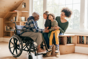 Senior in a wheelchair talking with daughter and grand children