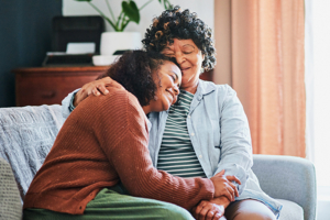 daughter hugging and caring for senior mother