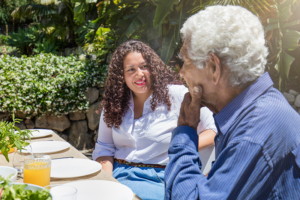 An older man and his daughter discuss how dementia affects the five senses as they have lunch.