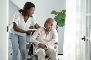 A woman assists her senior mother with hospital-at-home care.