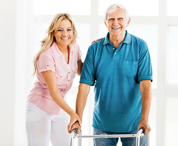 caregiver assisting senior man with walker
