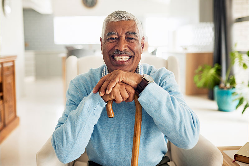 An older man confidently leans on his cane. He has learned fall prevention strategies to help him overcome his fear of falling.