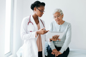 A doctor works on transforming dementia diagnosis discussions while talking to a senior patient.