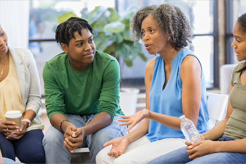 A woman has a meeting with her family members to discuss care issues, one of several important communication essentials for family caregivers.