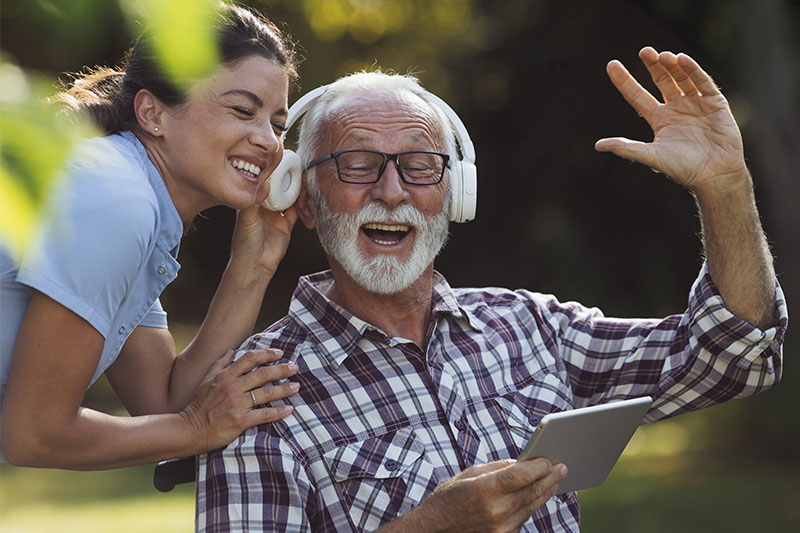 As a tactic for managing dementia agitation, a caregiver plays her elderly client’s favorite songs.