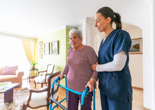 Caregiver assisting an older adult with mobility during daily activities