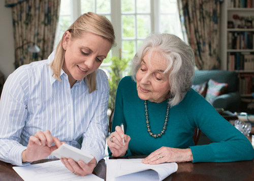 Long-Term Care Insurance Benefits Review Senior reviewing long-term care insurance benefits and claim paperwork with a care coordinator